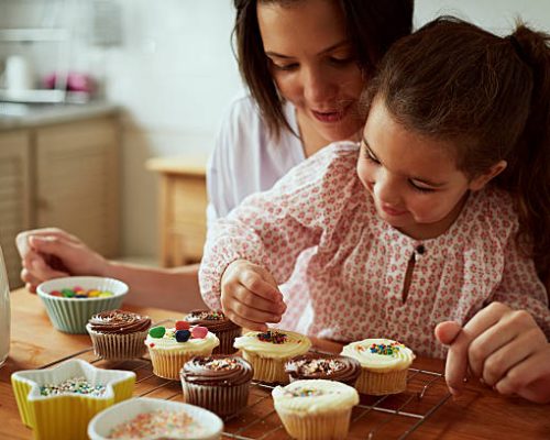 Mother and daughter baking in kitchen