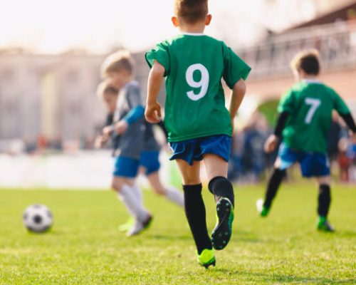 Boys playing in a soccer match. Football youth players kicking football ball in sunny day. Football competition tournament for kids